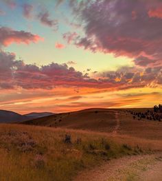 the sun is setting over an open field