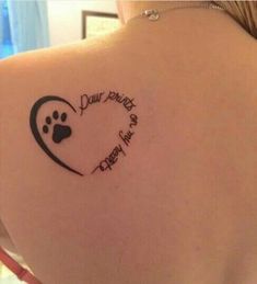 the back of a woman's shoulder with a dog paw and heart tattoo on it