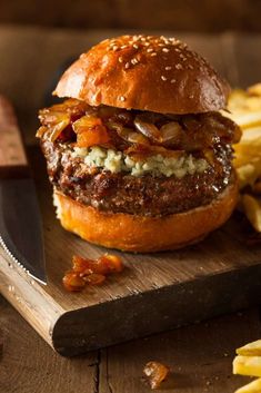 a cheeseburger on a cutting board with fries