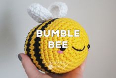 a hand holding a crocheted ball with the words bumble bee on it