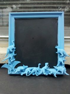 a blue frame sitting on top of a table next to a blackboard with birds painted on it