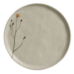 a white plate with a flower painted on the front and back side, against a white background