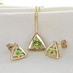 Elegant 9ct Gold peridot pendant and stud earring set. Ojewellery design and part of our first full gold collection. Produced in very small quantities you will only find this set from Ojewellery direct. Trillion cut peridot set in a raised triangle made of solid yellow gold. The design lifts the stone to allow light to filter to its back and show the stone of with an elegant sparkle. The natural green peridot is from Arizona USA. The stones measure 5 x 5mm in the pendant and 4 x 4mm in each stud Gift Yellow Gold Diamond Cut Jewelry Sets, Fine Jewelry With Peridot And Matching Earrings, Yellow Gold Polished Peridot Jewelry, Gold Peridot Jewelry With Polished Finish, Yellow Gold Peridot Jewelry With Polished Finish, Yellow Gold Jewelry With Matching Earrings For May Birthstone, Uk Design, Peridot Pendant, Peridot Necklace