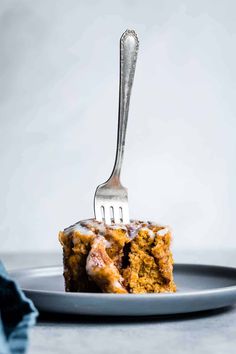 a fork sticking into a piece of cake on a plate