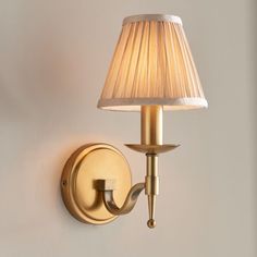 a wall light that is on the side of a wall next to a lamp shade