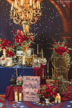 a table topped with lots of candles next to a blue table cloth covered in red flowers