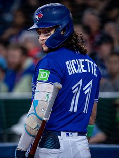 a baseball player holding a bat in his hand and wearing a catchers mitt