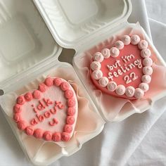 two heart shaped cakes in plastic containers with writing on them