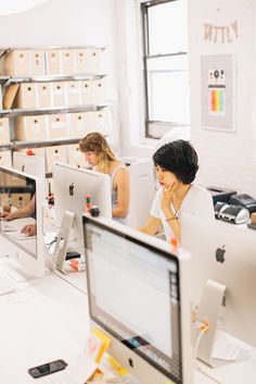 two women working on computers in an office