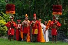 a group of men dressed in red and yellow outfits standing next to each other on grass