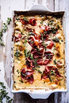 a casserole dish with cheese, bacon and herbs