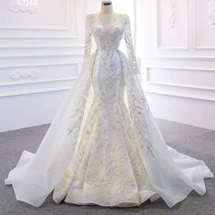 a wedding dress on display in a white room