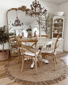 a dining room table with chairs and a chandelier hanging from the ceiling above it