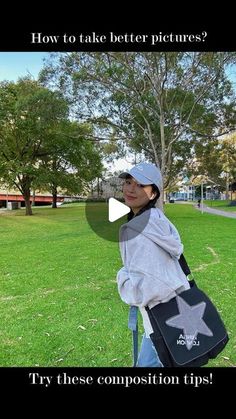 a woman standing in the grass holding a black and white bag with an arrow on it