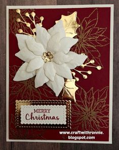 a christmas card with white poinsettis and gold foil