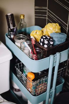 a blue cart filled with bathroom items next to a toilet