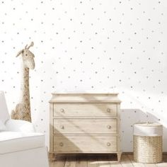 a baby's room with white furniture and polka dot wallpaper