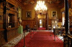 an ornately decorated room with chandelier and red carpet