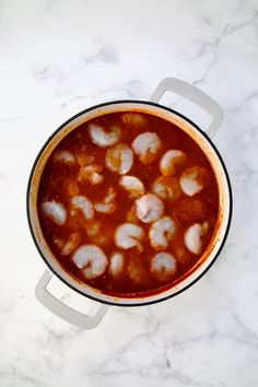 a pot filled with food sitting on top of a white counter