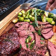 the steak is prepared and ready to be served on the bbq grill with brussel sprouts