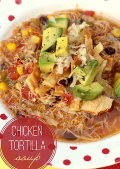 chicken tortilla soup with avocado, corn and tomatoes in a white bowl