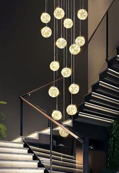 a modern chandelier hanging from the ceiling in front of stairs and staircases