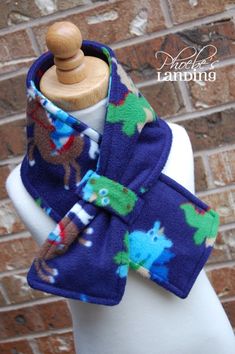 a close up of a mannequin wearing a blue scarf with animals on it