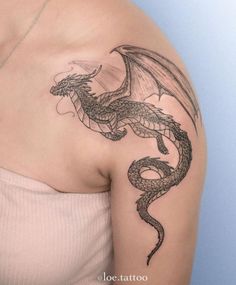 a woman with a dragon tattoo on her shoulder