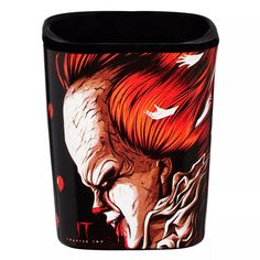 a ceramic mug with the face of a clown painted on it