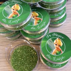 tins filled with green glitter sitting on top of a table