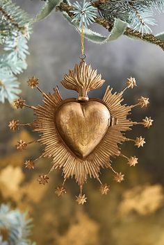 a gold heart ornament hanging from a tree