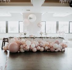 a long table with balloons on it in the middle of a room