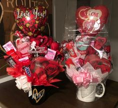 two valentine's day gifts are sitting on a table next to a coffee mug