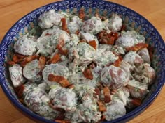 a blue bowl filled with food on top of a wooden table