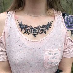 a woman with tattoos on her chest wearing a pink shirt