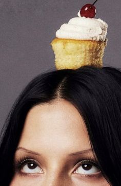 a woman with a cupcake on top of her head