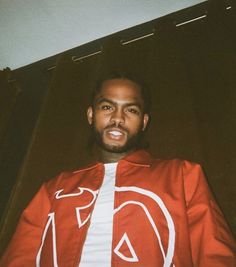 a man wearing a red jacket with white letters on it