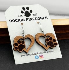 "Heart Dog Paw Earrings are made from solid cherry wood and poplar wood. These dangle earrings are laser cut and engraved in a heart shape with a dog paw on the side. Available in two sizes - small and large. These solid wood earrings would make a great gift for dog lovers. They are perfect for any occasion. Treat yourself to a new pair of beautiful earrings! Everyone will love them! Metal options are Sterling Silver or Stainless Steel (hypoallergenic, lead and nickel free).  Highlights * Handmade * Solid Cherry wood  * Solid Poplar wood  * Laser cut and engraved * Sterling Silver or Stainless Steel (hypoallergenic) metal options * Length - small 1.75\" including ear wire and large 2.25\" including ear wire * Thickness is approximately 1/8\" Metal Options * Sterling Silver ear wire, flat f Laser Earrings, Laser Engraved Earrings, Paw Earrings, Laser Engraved Metal, Glow Forge, Laser Cut Wood Earrings, Laser Cut Wood Crafts, Laser Projects, Engraved Earrings