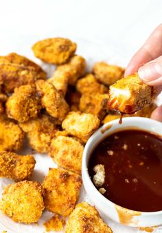 a person dipping sauce onto some fried food