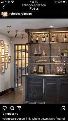 an image of a bar in the middle of a room with lots of bottles on it