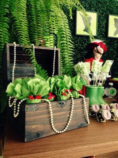 a wooden trunk filled with lots of flowers and greenery sitting on top of a table