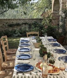 the table is set with blue plates and place settings