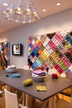 a large table with many different colored items on it and a chandelier hanging from the ceiling