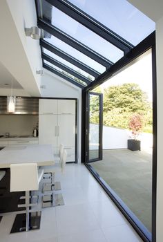 an open kitchen and dining room with glass walls