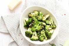 a bowl filled with broccoli on top of a table