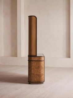 a tall wooden object sitting on top of a hard wood floor in an empty room