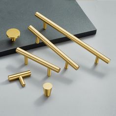 several brass handles and knobs on a gray surface