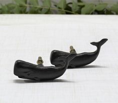 two black whale shaped objects sitting on top of a table