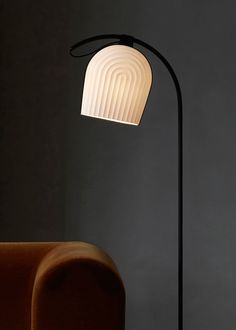 a lamp that is sitting on top of a floor next to a chair and table