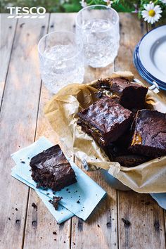 chocolate brownies on a wooden table with ice water and flowers